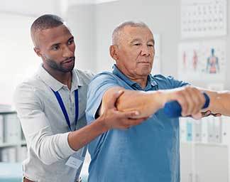 Physical therapy session showing a therapist guiding a patient’s arm through a controlled exercise using a light weight to improve strength and mobility