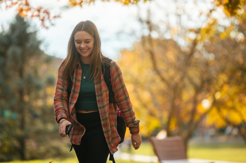 student smiling and walking to class