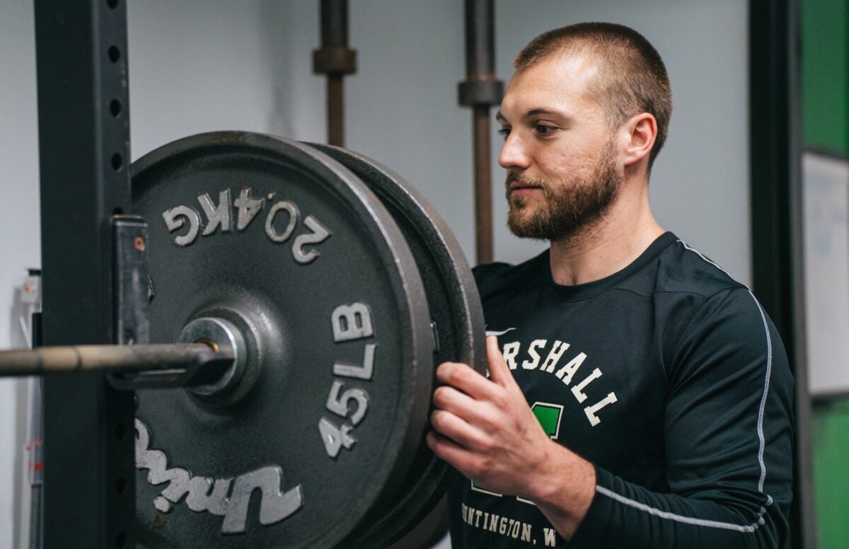 student putting a weight on a bar