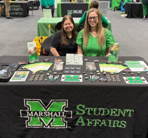 two women sitting at an information table for Student Affairs