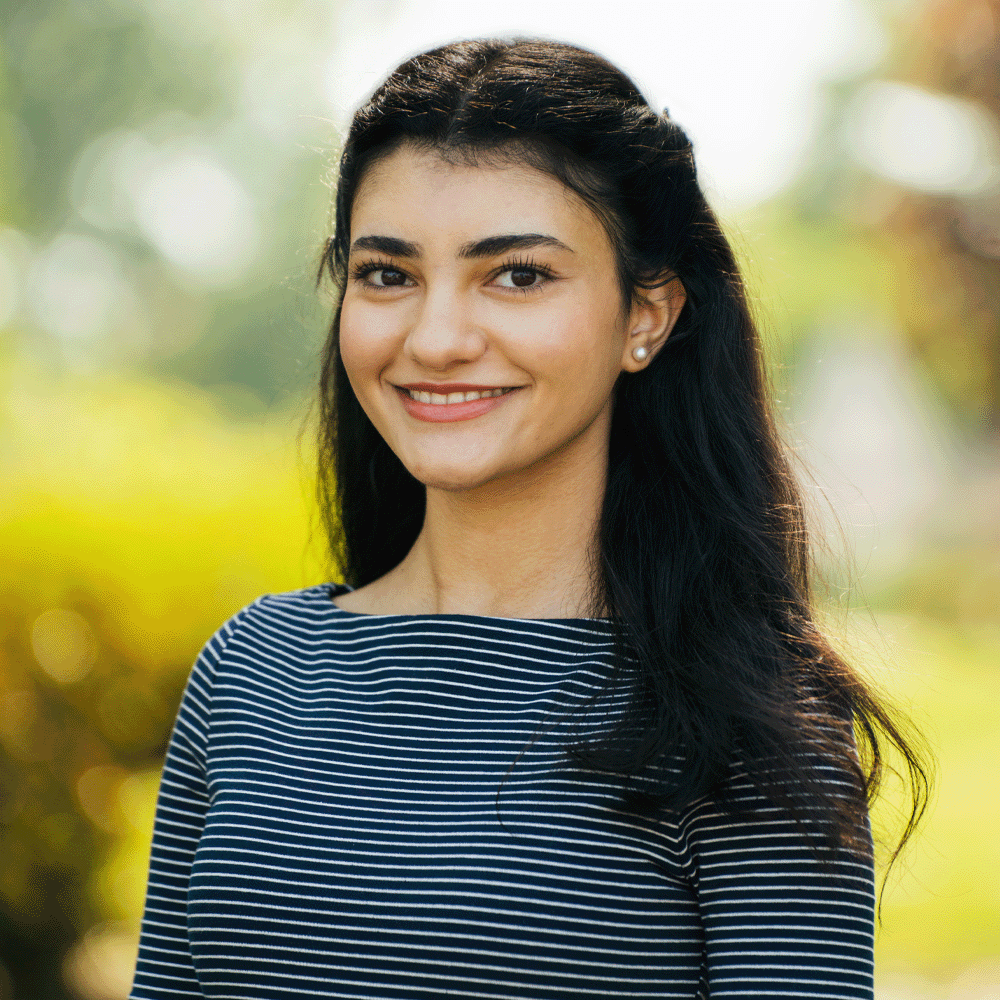 Headshot photo of woman with black hair wearing a black and white striped shirt.