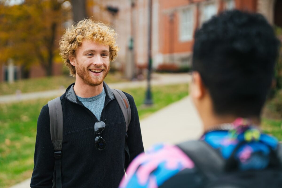 two students talking on campus outside
