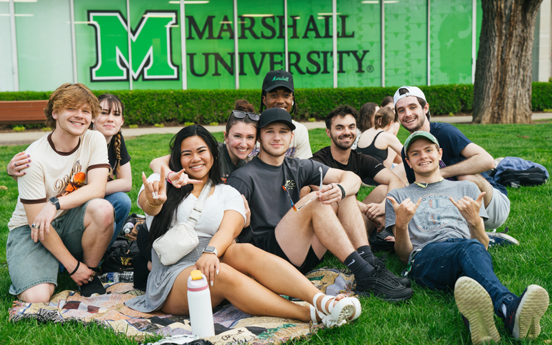 A group of student gather for a photo on Buskirk Field at Marshall University