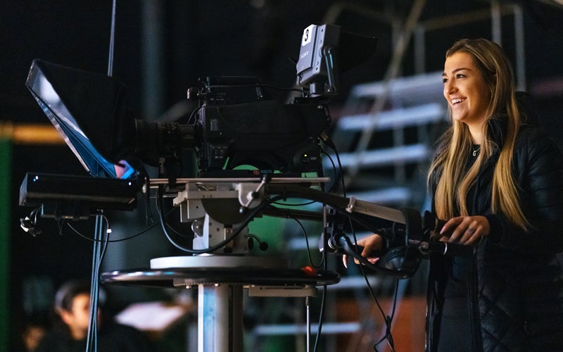 A Marshall University student uses a video camera in a Journalism School TV studio