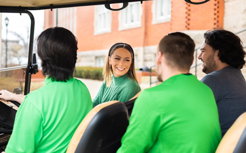 A Marshall Tour Guide talks to visitors during a golf cart tour of campus
