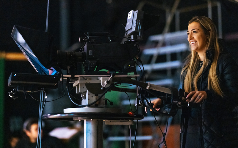 A Marshall University student uses a video camera in a Journalism School TV studio