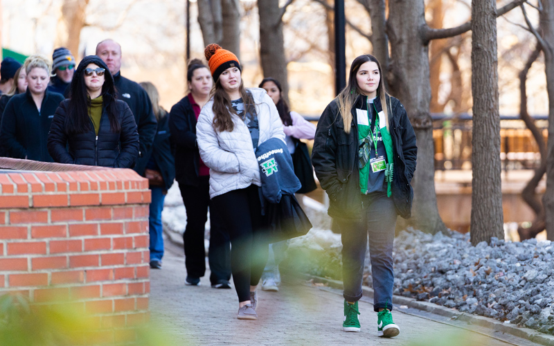 A tour guide gives a walking tour of Marshall University's Huntington campus