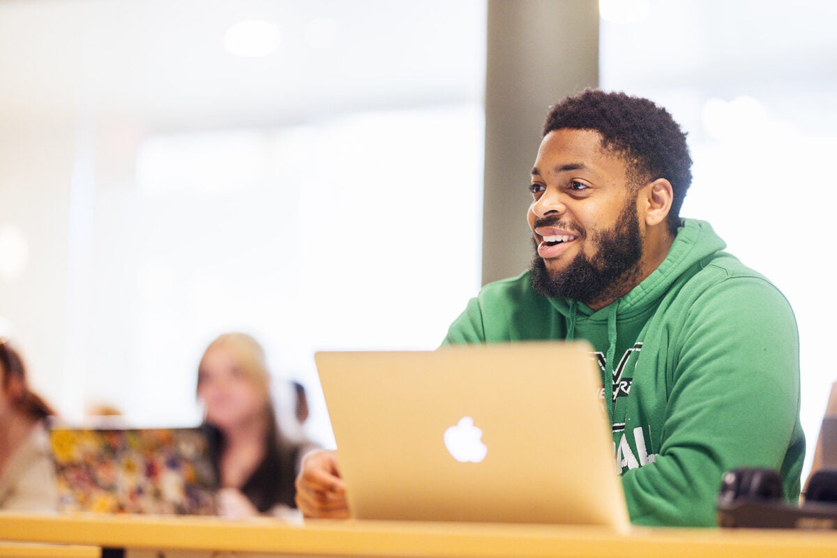 Marshall student taking notes in class