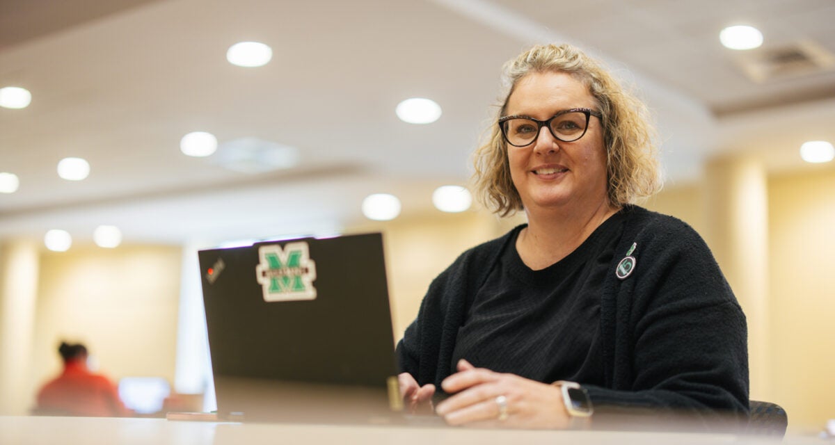Adult student on a laptop in a library setting
