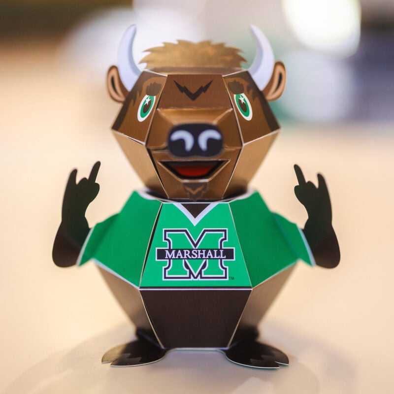 A pop-up, paper Marco mascot sits on a table