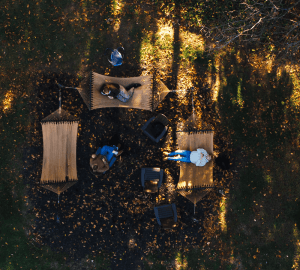 overhead shot of student laying in hammocks on campus with leaves on ground