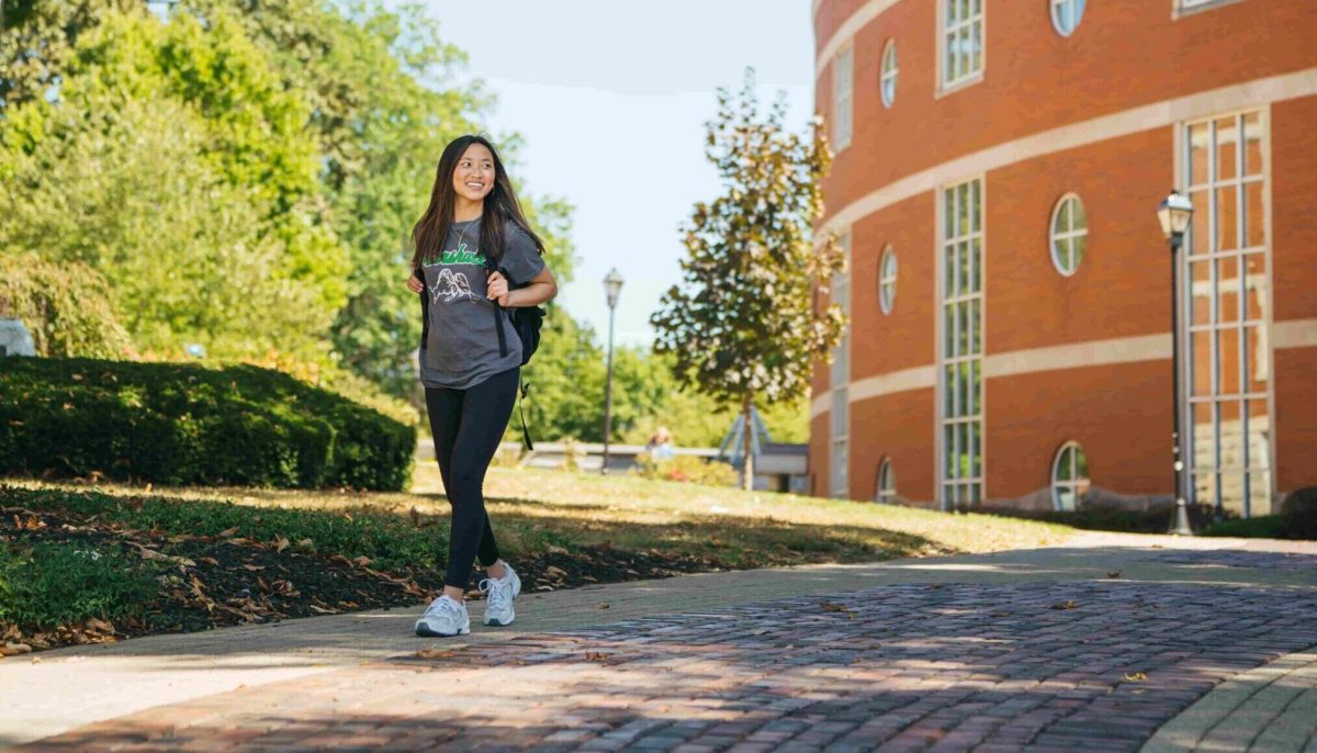 photo of student walking on campus during summer