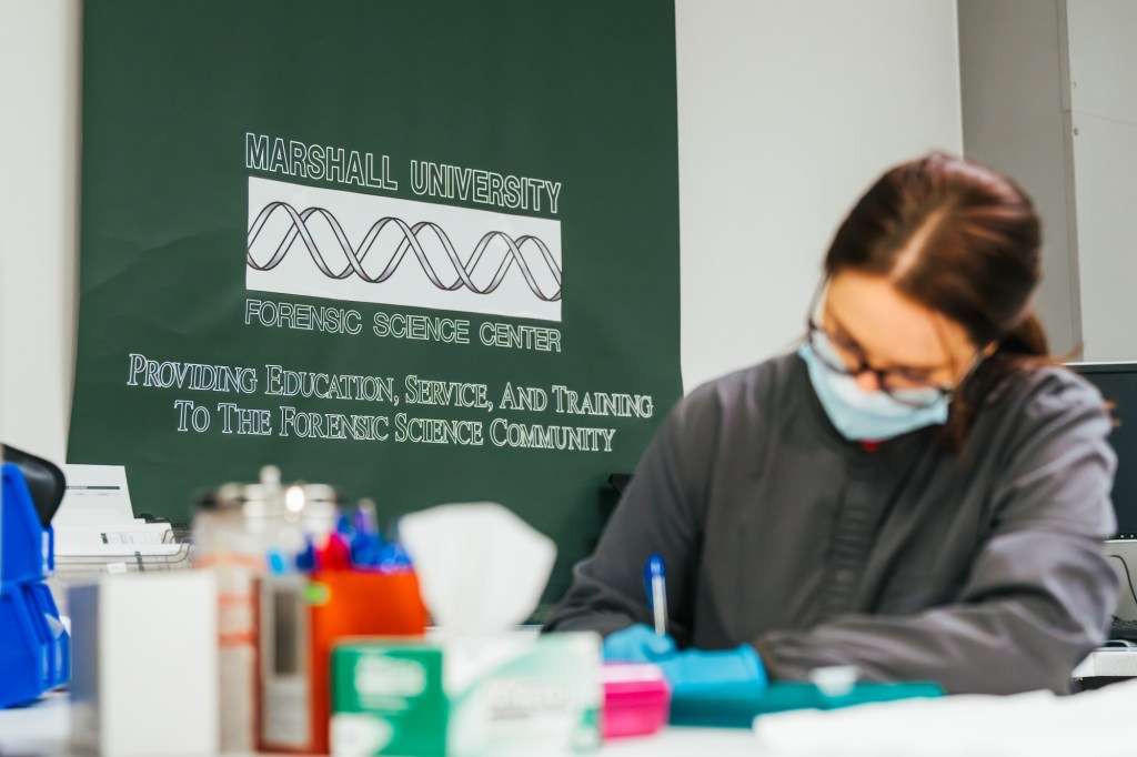 student workin with a mask on in the Marshall University Forensic Science Center