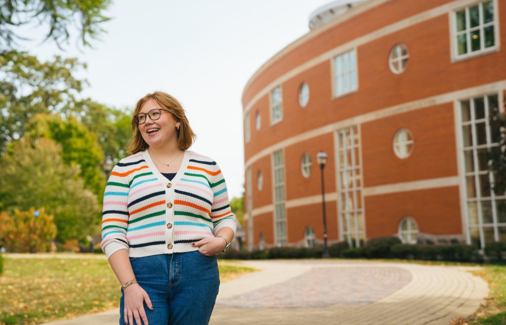 SLP student smiling and looking to the left outside next to Drinko Library