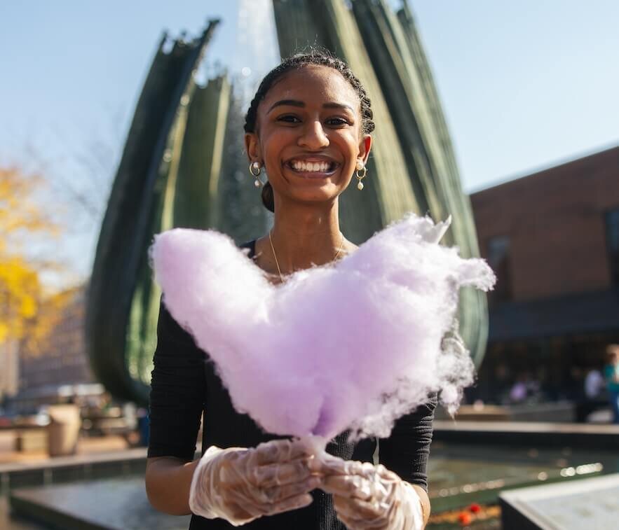 photo of student with cotton candy on student center plaza