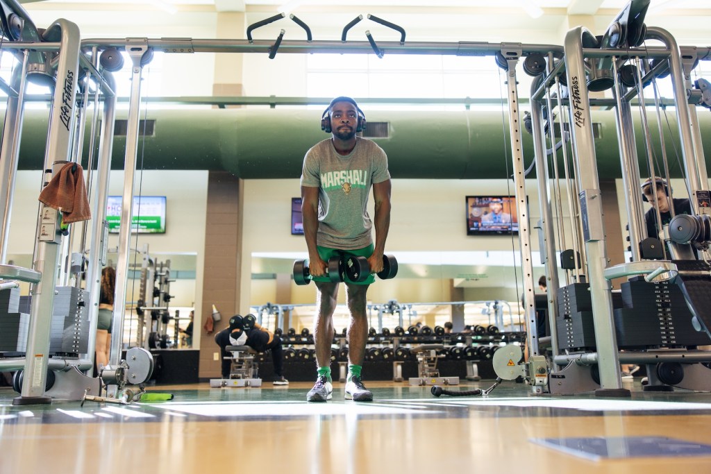 student lifting weights in the rec center
