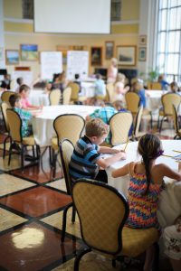 Images of kids in a classroom sitting around tables