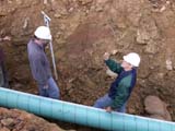 Photo from Sedimentation and Stratigraphy field trip showing students in the trenches of an in-ground pipeline installation