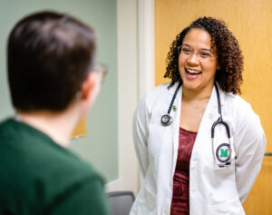 Taylor Pearson, Marshall University Joan C. Edwards School of Medicine, laughs with a patient during a consultation