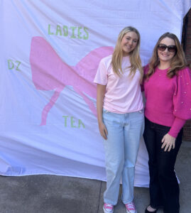 Sydney Barbour with her mother, Michelle Biggs in front of a sorority banner