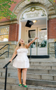 Haley Prather tosses her hat outside of the Marshall College entrance of Old Main
