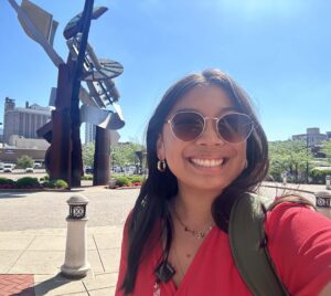 Gracie takes a selfie with the Clay Center statue behind her
