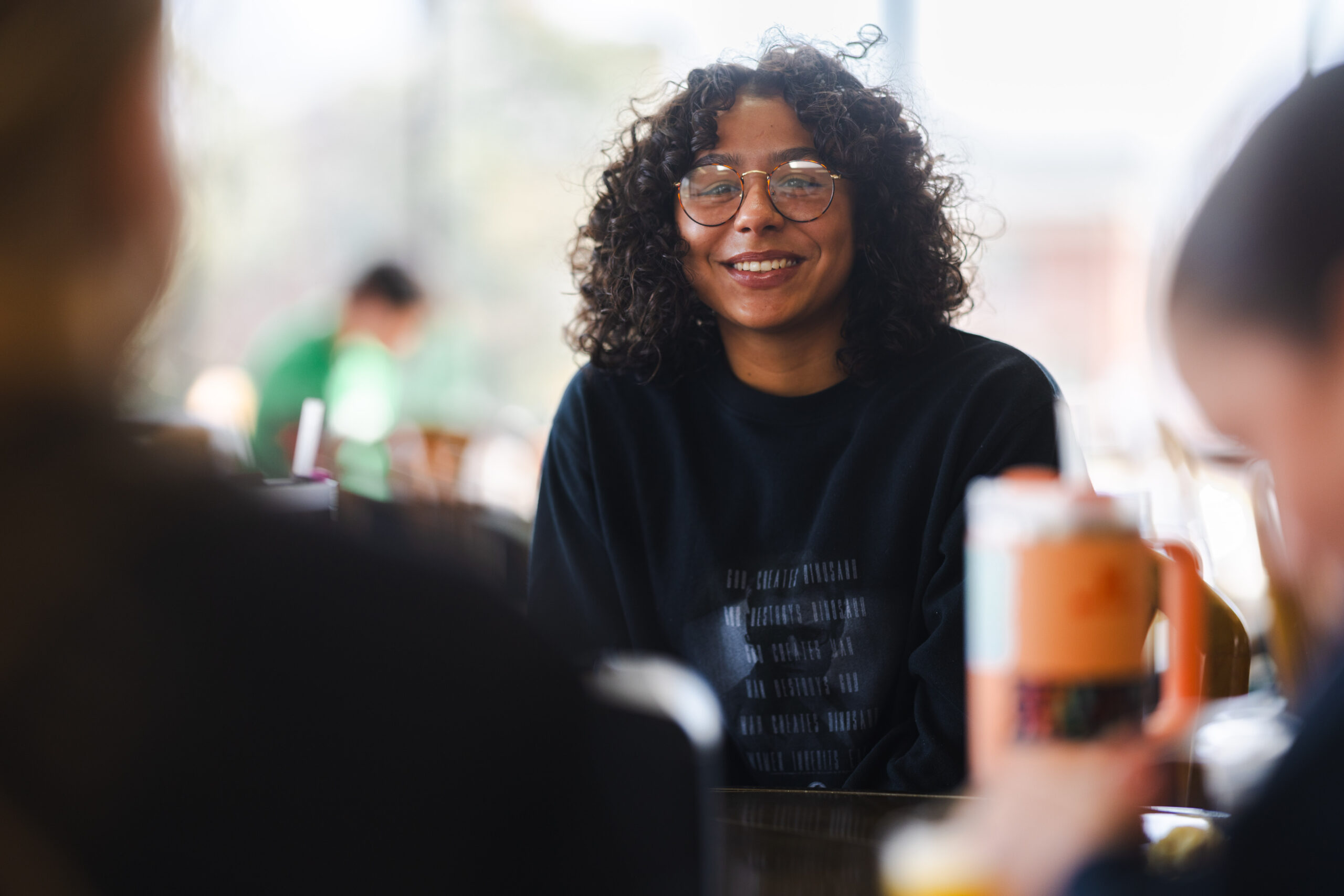 student at marshall talking amongst other students sitting at a table