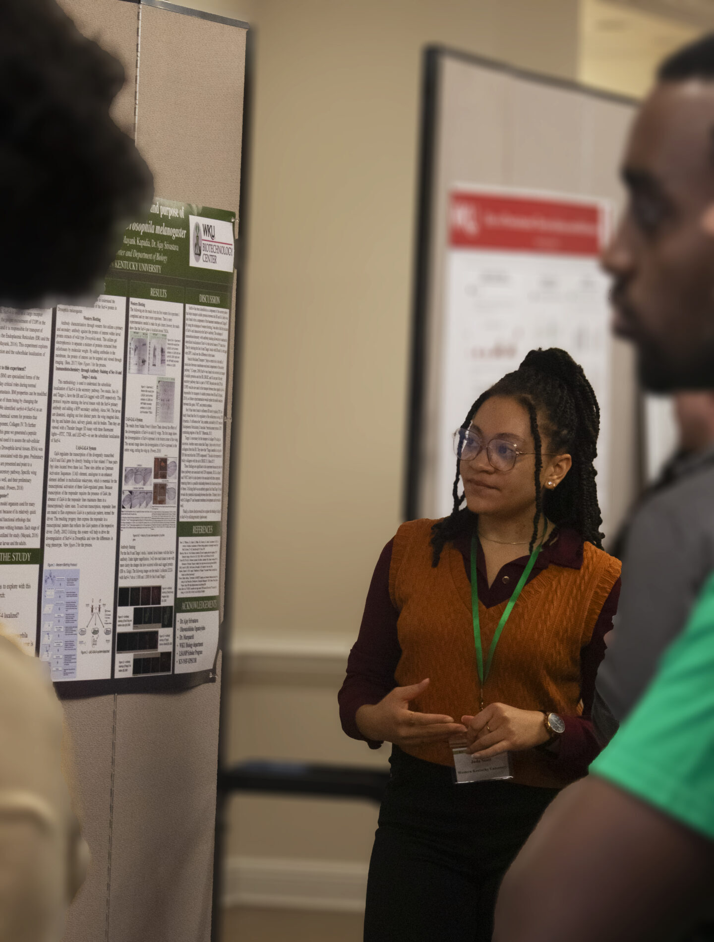 A student answers questions about their poster presentation.