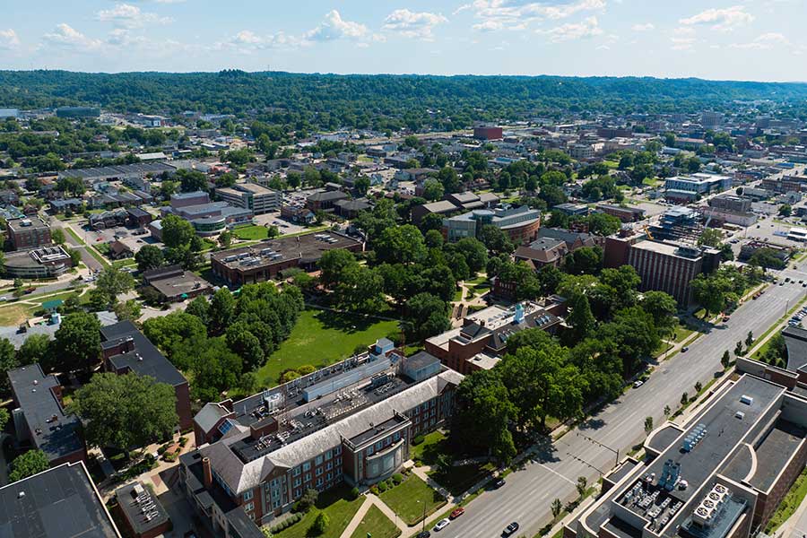 Aerial view of Marshall University's Huntington campus with the Science Building in the foreground and mature trees, lawns, and greenspaces woven throughout the campus landscape.