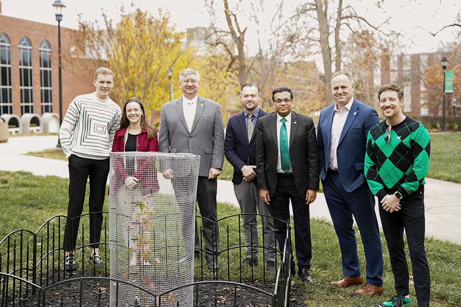 Marshall University officials, faculty members, and supporters stand beside the Artemis Moon Tree during its dedication ceremony on the Huntington campus.