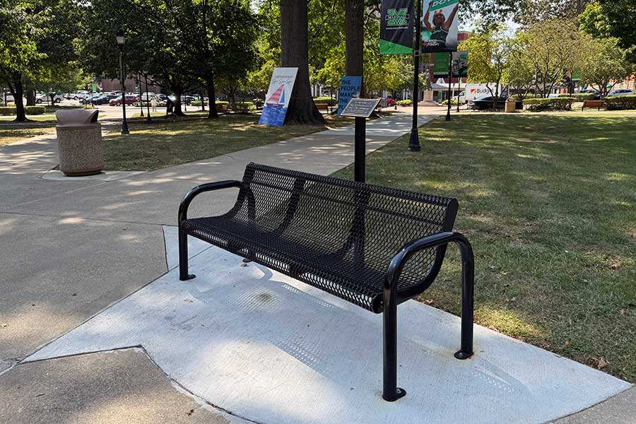 Memorial bench beside a campus walkway with a commemorative plaque honoring MUSOM graduate Paul W. Ambrose and those who lost their lives on September 11, 2001.