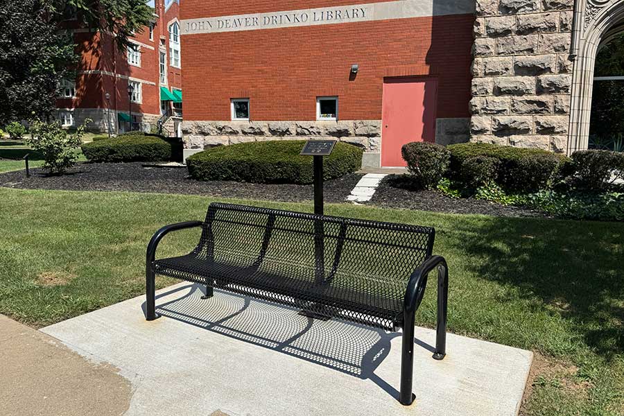 Memorial bench outside the John Deaver Drinko Library honoring Joan C. Browning, a West Virginia Freedom Rider, with a commemorative plaque positioned behind the bench.