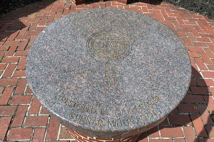Granite tabletop at the center of the Omicron Delta Kappa Circle engraved with the ODK emblem and the inscription "Restored by ODK Member Gunnar Miller 2001."