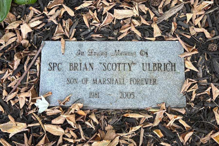 Stone memorial marker at the base of the Brian "Scotty" Ulbrich Memorial Tree engraved with the inscription, "In Loving Memory of SPC Brian 'Scotty' Ulbrich, Son of Marshall Forever, 1981-2005."