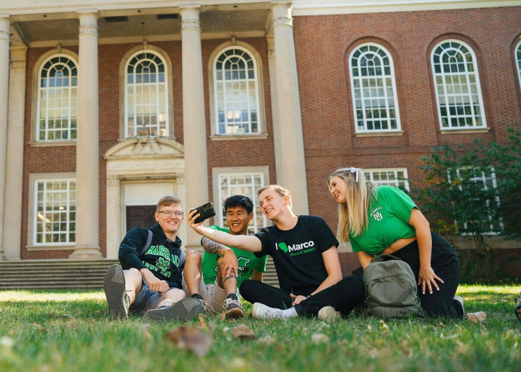 students sitting in front of Morrow Library in the grass