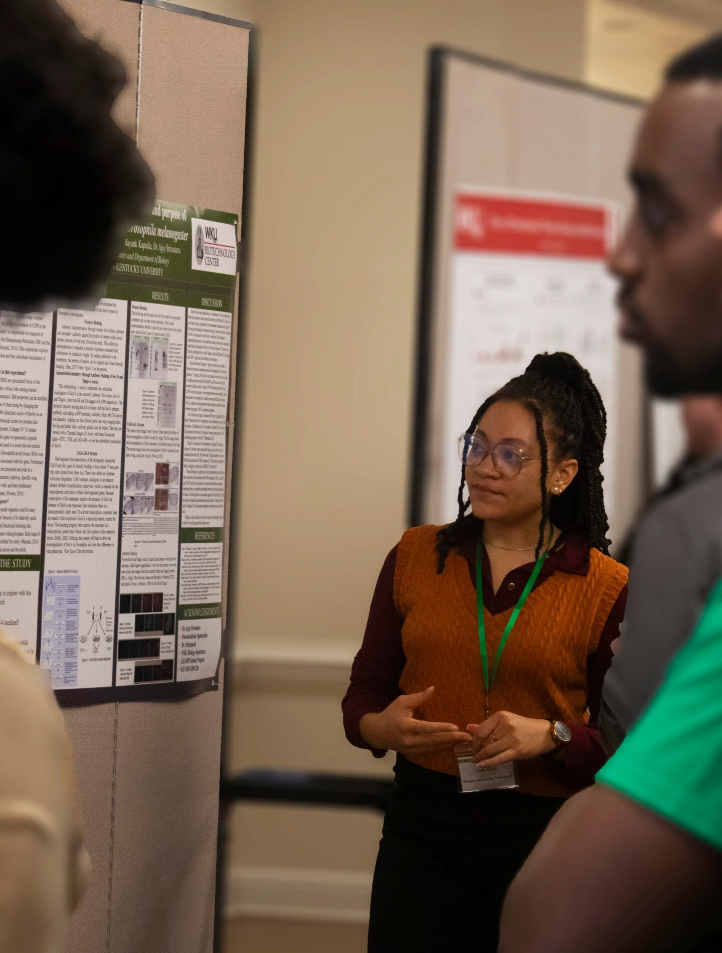 A student answers questions about their poster presentation.