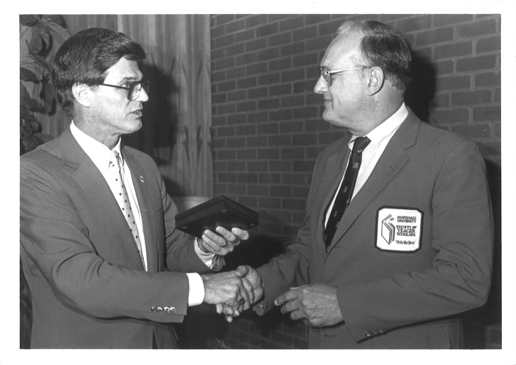 Two men in suits at a formal ceremony.